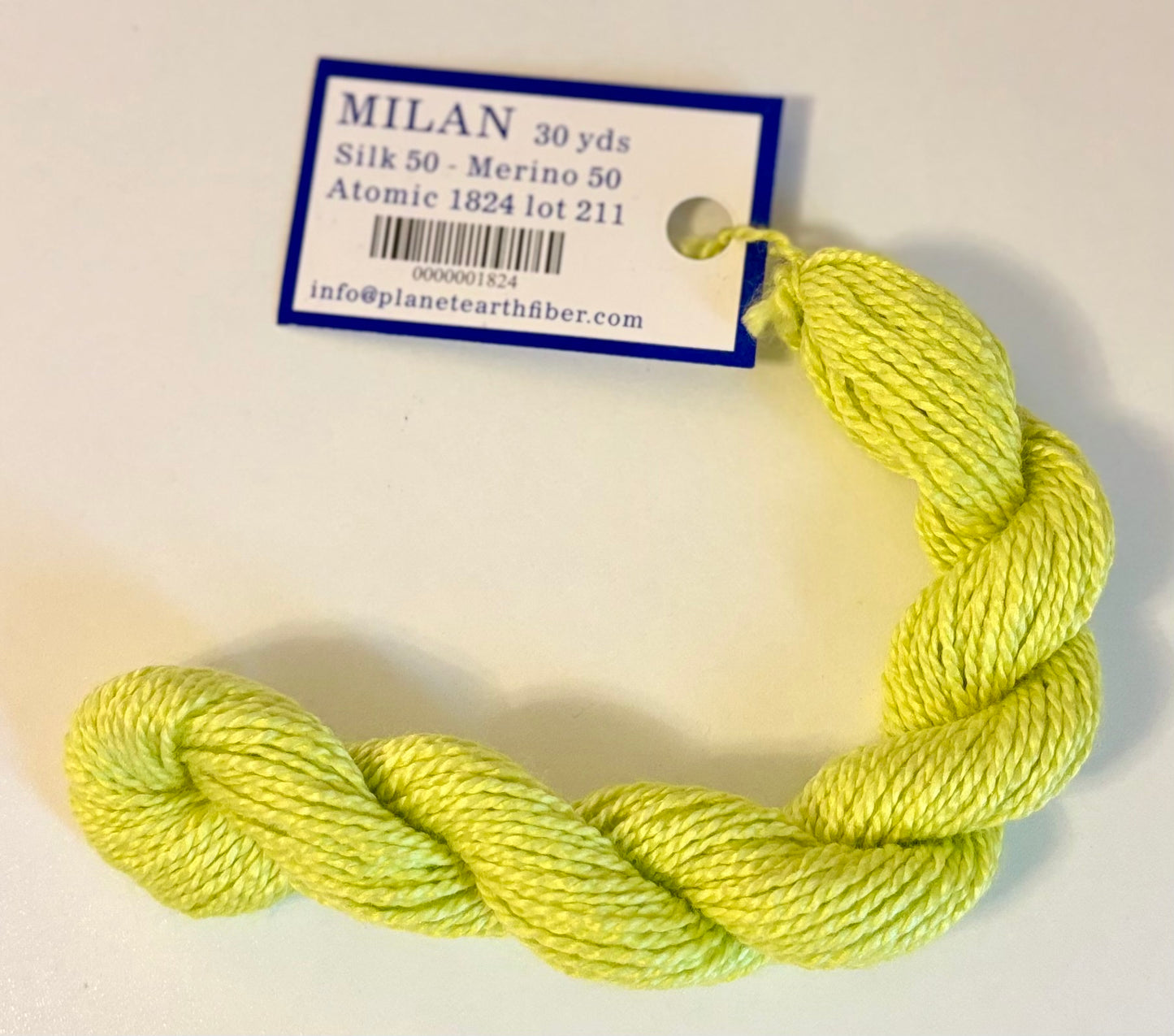 Neon green yarn skein with a label on a white background