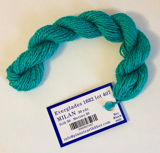 Turquoise yarn skein with a label on a white background